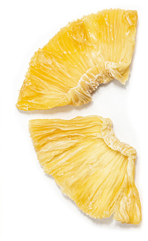 Due fette di ananas giallo brillante su uno sfondo bianco.